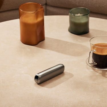 Accessorio Pannello Frontale Lunar Silver di Ploom AURA su un tavolo.