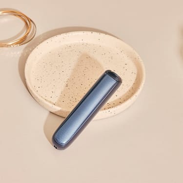 Pannelli frontali Ploom AURA con motivo Navy Blue posizionati su un tavolo.