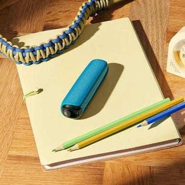 Dispositivo Ploom con cover posteriore Ocean Blue su un quaderno