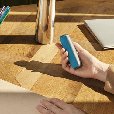 Mano che tiene la cover posteriore per Ploom AURA Ocean Blue per migliorare impugnatura e protezione del dispositivo