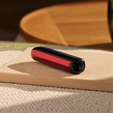 Ploom AURA front panel Lava Red accessory attached to device on a table.