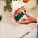 Hand placing an Amazon Green Back Cover on a Ploom AURA device