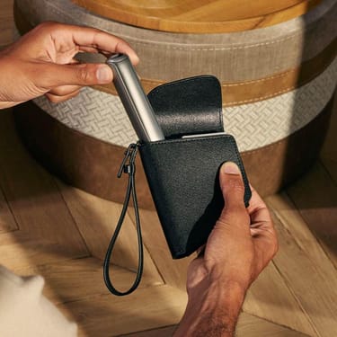 Una mano tiene un accessorio Ploom Astuccio Duo Jet Black