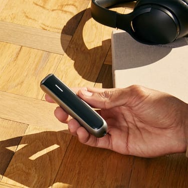 Dispositivo Ploom AURA con pannello frontale Jet Black tenuto in mano.
