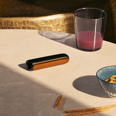 Ploom AURA front panel Mango Sorbet accessory attached to device on a table.