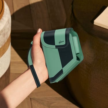 Una mano che tiene un accessorio della custodia Ploom Duo Teal Electric Pop