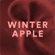 Visual astratto Winter Apple con particelle rosse e lettering centrale.