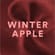 Visual astratto Winter Apple con particelle rosse e lettering centrale.